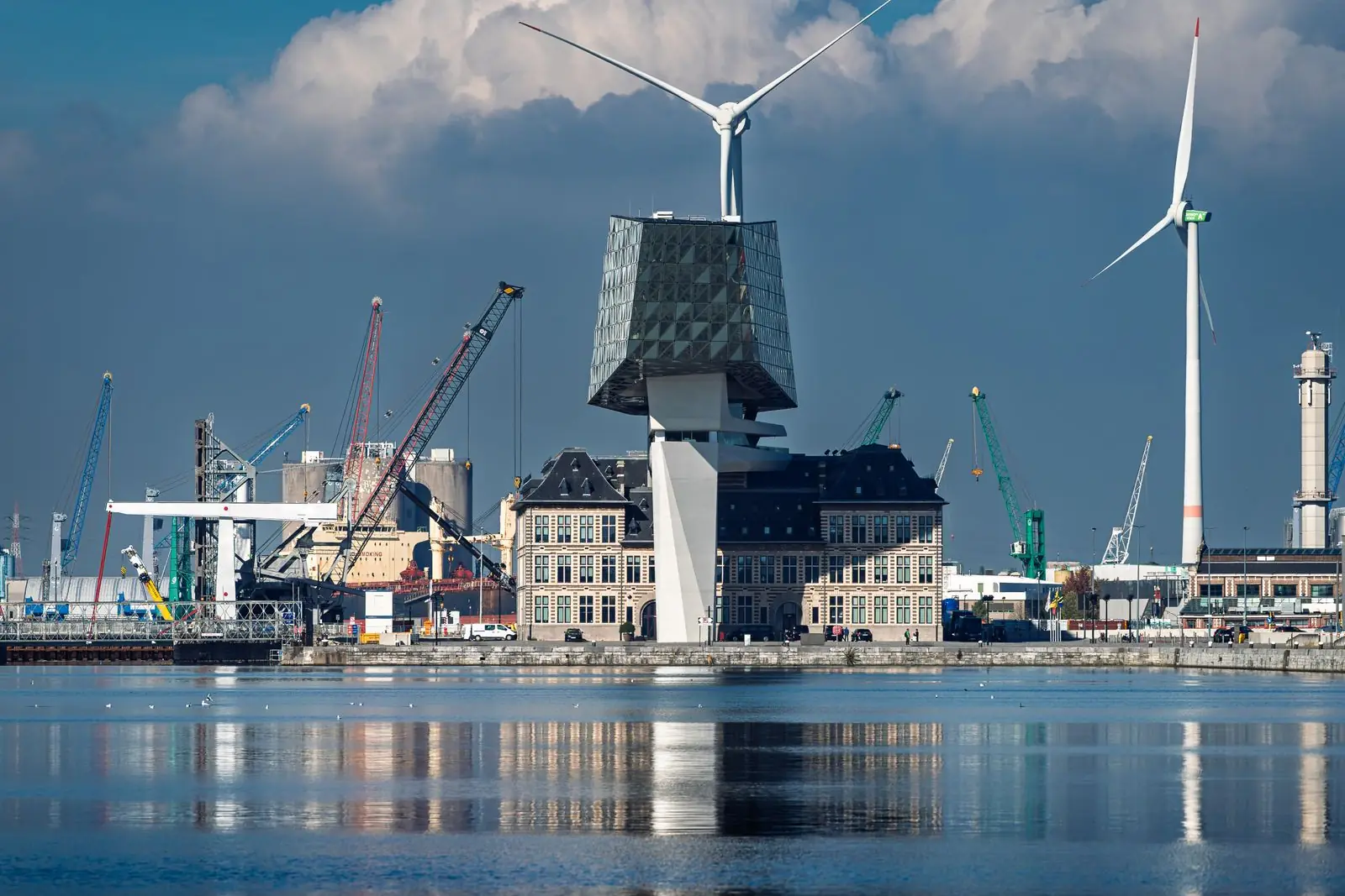Havengebied van Antwerpen met havenkranen, windturbines en het Havenhuis aan het water